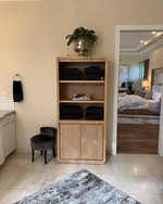 Small room with narrow tall cabinet near a dresser